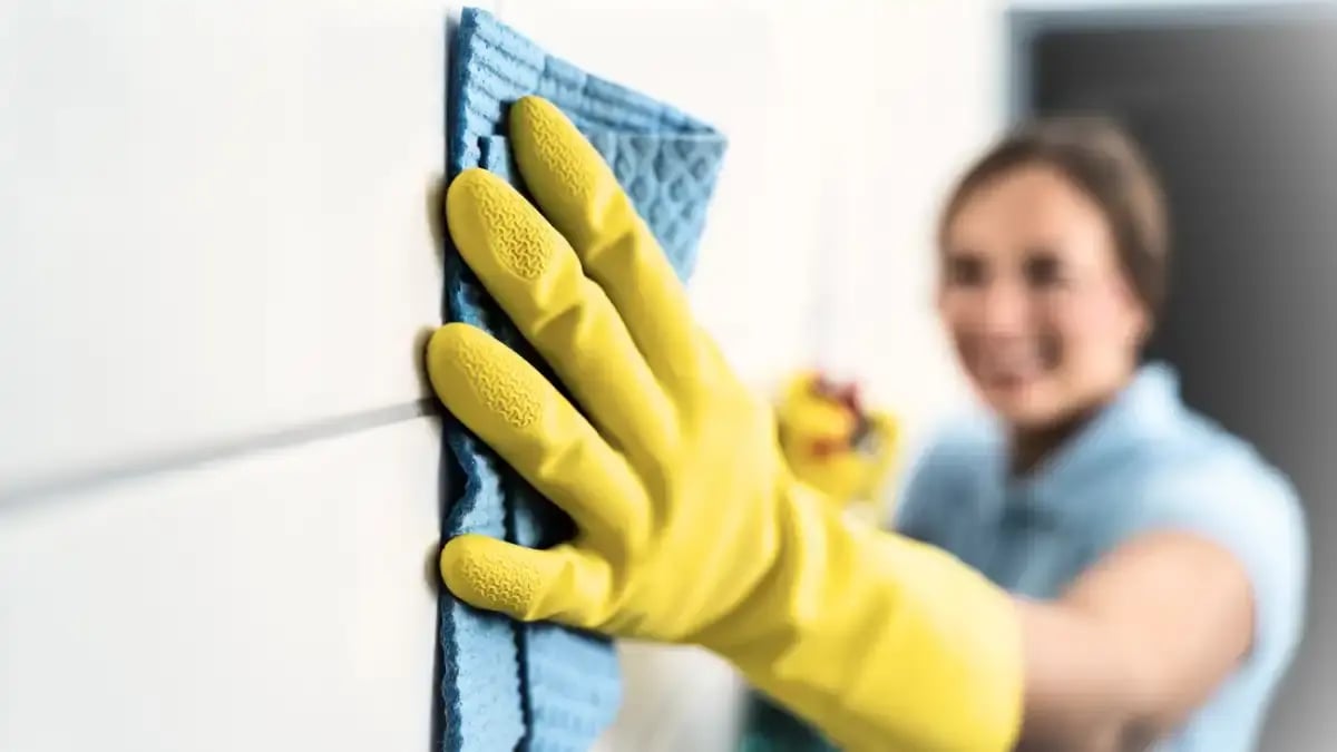 A woman cleaning the walls of a fire-damaged site.