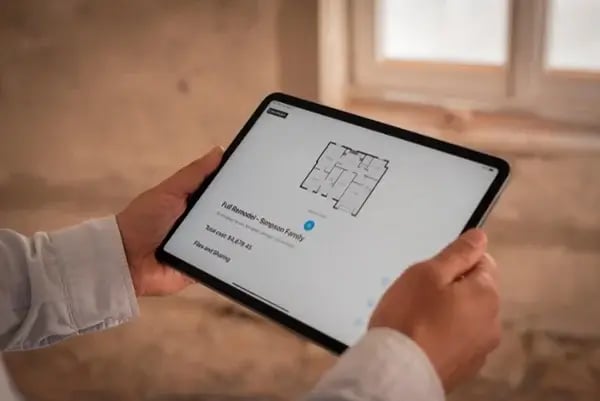 Contractor holding and ipad tablet with the magicplan app floor plan open in a property renovation restoration
