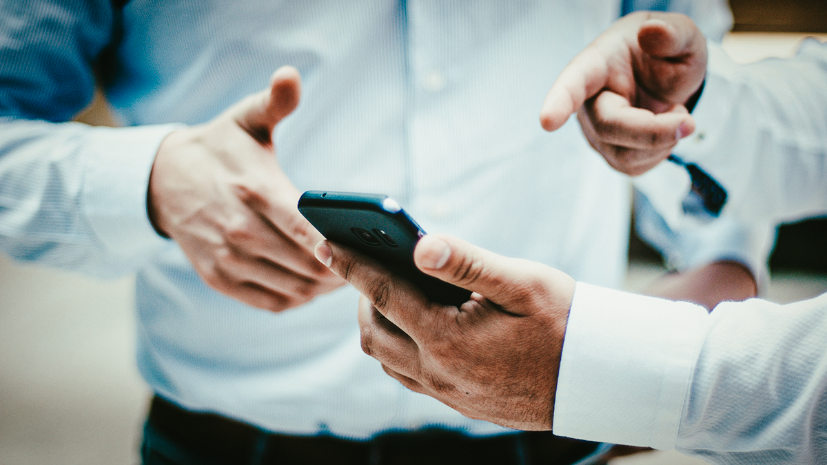 Restoration contractor connecting with local business and professionals to gain referral customer by showing them his job on his smartphone
