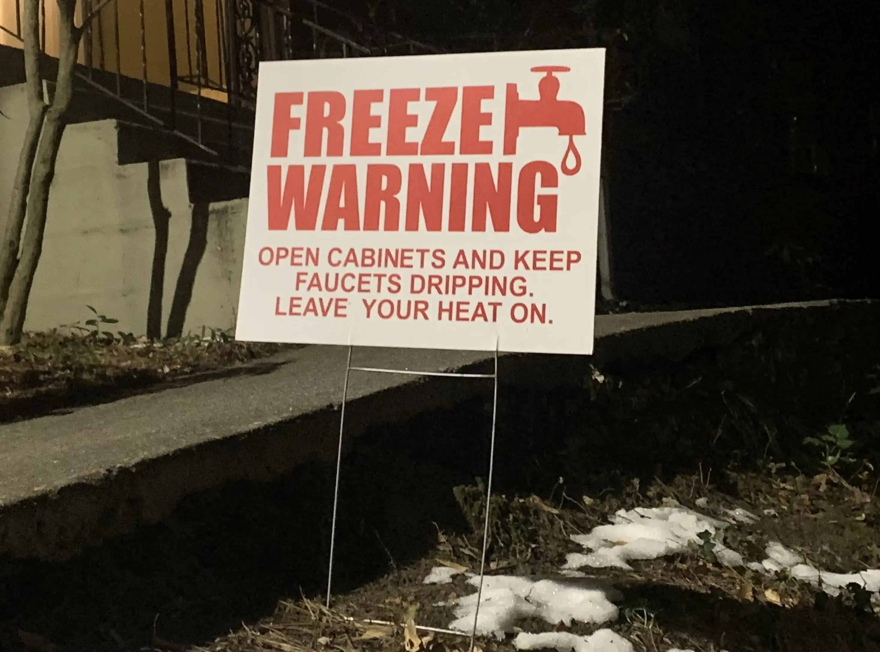 Freeze warning sign in atlanta georgia after winter storm with snow to open cabinets and keep faucets dripping causing water damage and pipe breaks for restoration jobs.