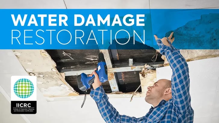 Restoration professional fixing a water damage ceiling after drying mitigation with the IICRC s500 logo